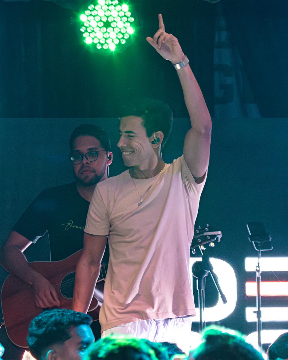 Anderson Junior no palco com músico e público ao fundo