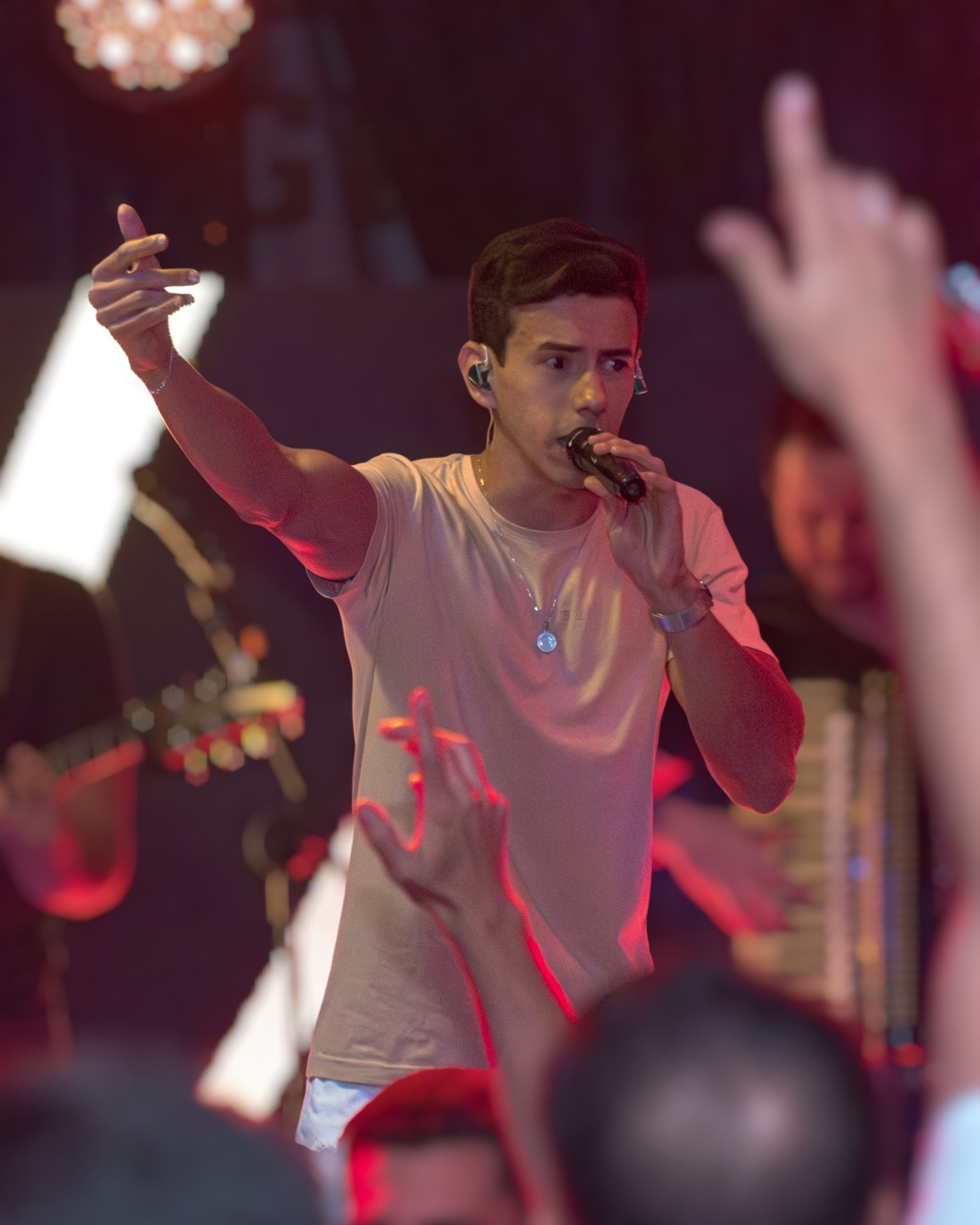 Anderson Junior cantando sob luzes vermelhas e verdes