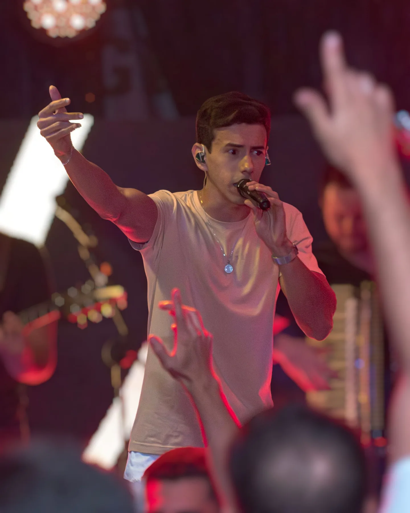 Anderson Junior cantando sob luzes vermelhas e verdes
